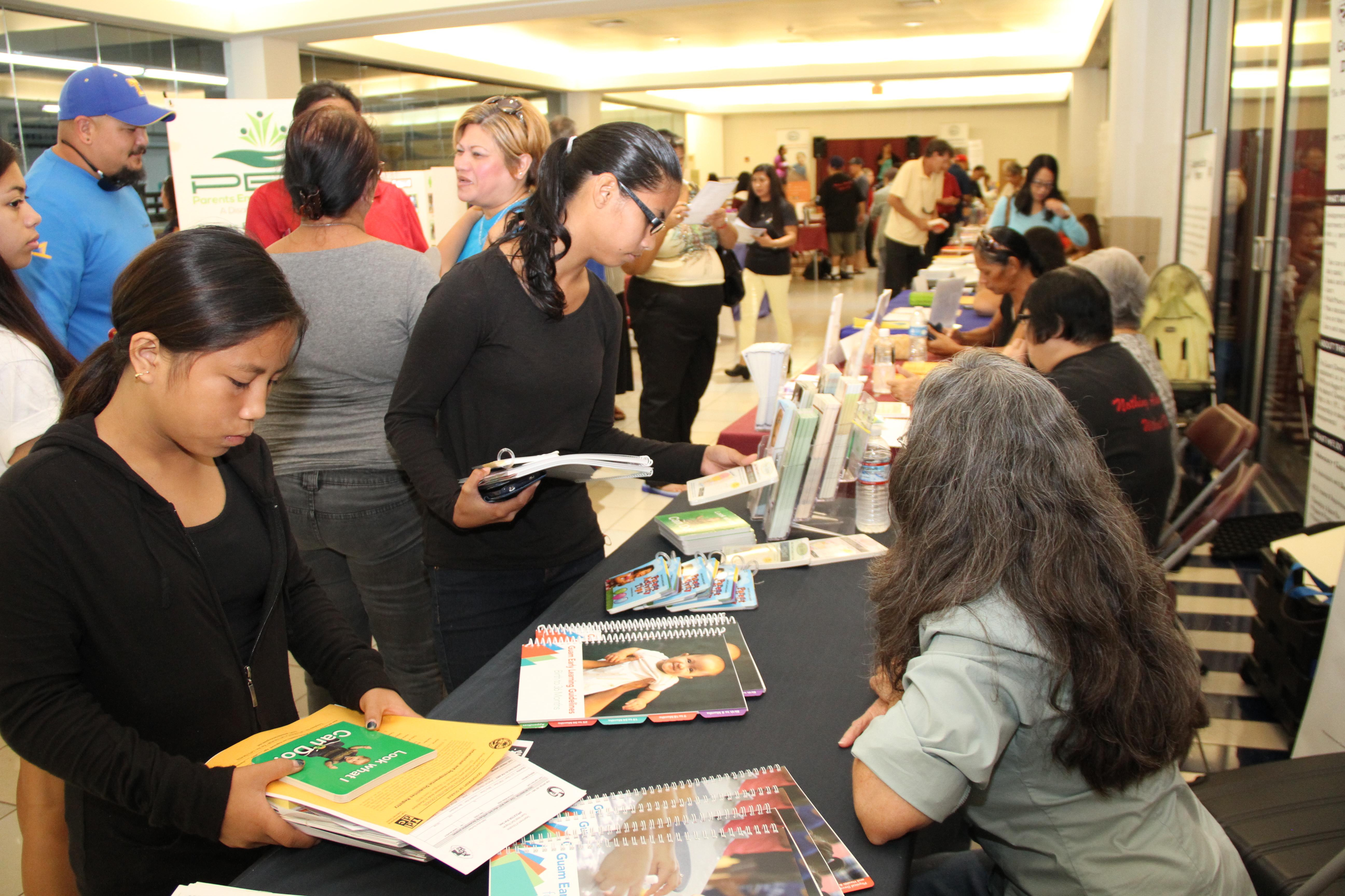 Fair participants review resources offered by the Guam Early Hearing Detection and Intervention (Guam EHDI) Program.