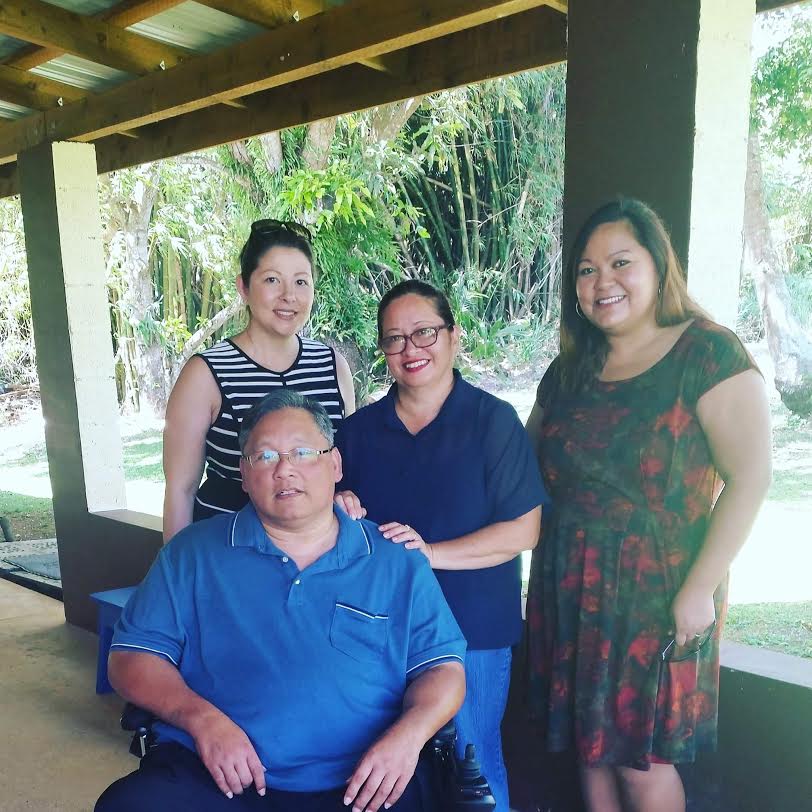 GSAT Program Coordinator Carla Torres (standing left) poses with KUAM news reporter Joan Aguon Charfauros (standing right) and Mr. and Mrs. Andy Arceo after filming an interview with the Arceos.  Andy Arceo recently received a GOAL-AT loan to finance an accessible van which would allow Mr.Arceo to transport and travel in his power wheelchair.  Andy shares this story and how he can now return to work as result during a 5 part series airing on KUAM News primetime.
