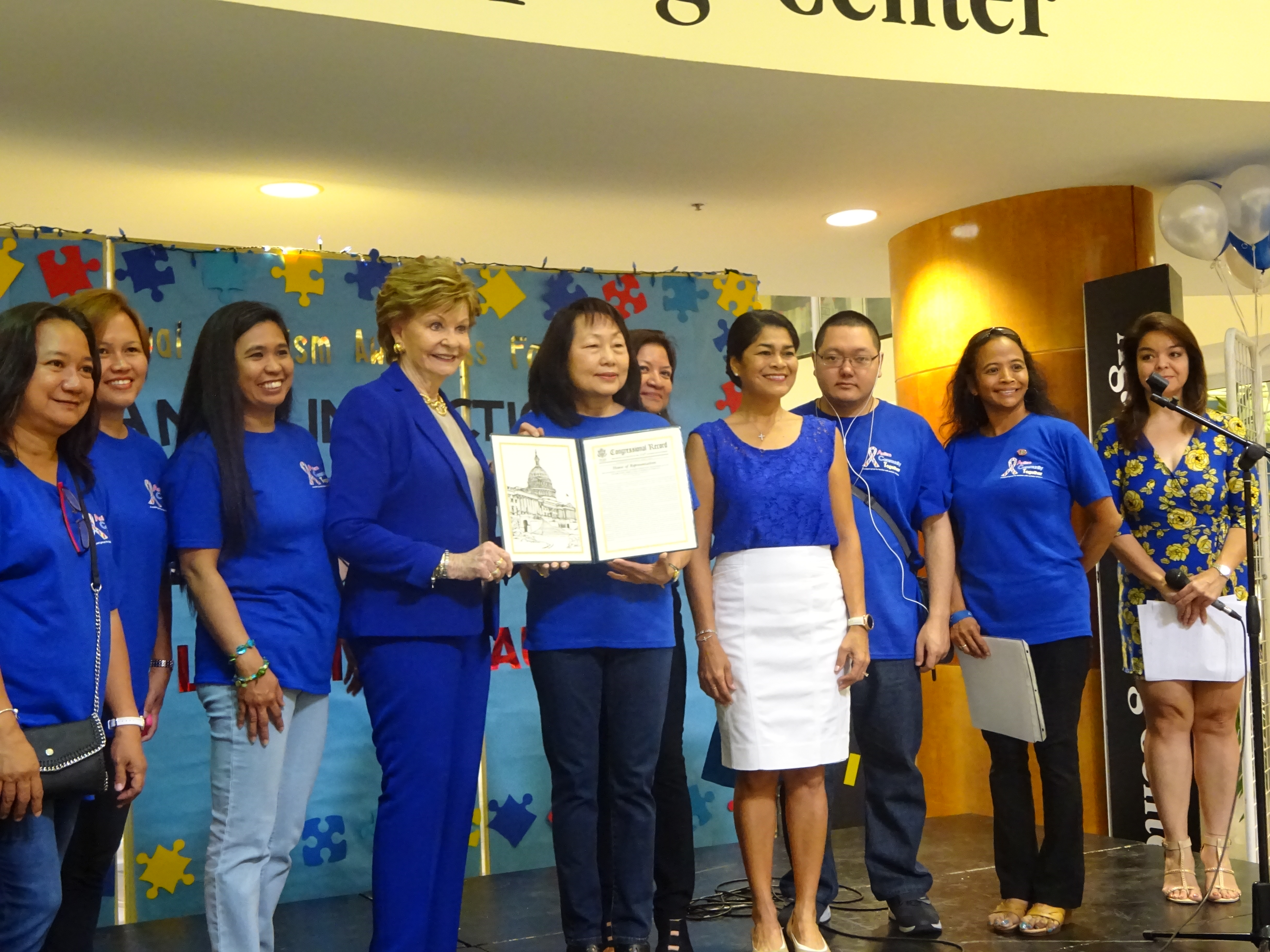 Members of the Autism Community Together (ACT) non-profit organization facilitated the opening ceremonies of the Autism Month celebration and outreach event held at the Agana Shopping Center's Center Court on Saturday, April 3.  Lou Mesa, President of ACT (holding the certificate) and the officers were joined by Congresswoman Madeliene Bordallo (to Lou's left) and First Lady Christine Calvo (to Lou's right) on stage to applaud the efforts of the community in promoting increased awareness of autism on island.