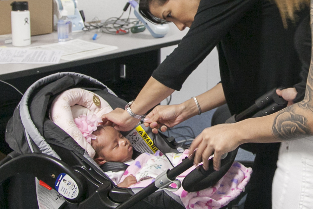 Dr. Renee Koffend (back right) conducts hearing screening test using an AABR device on an infant.