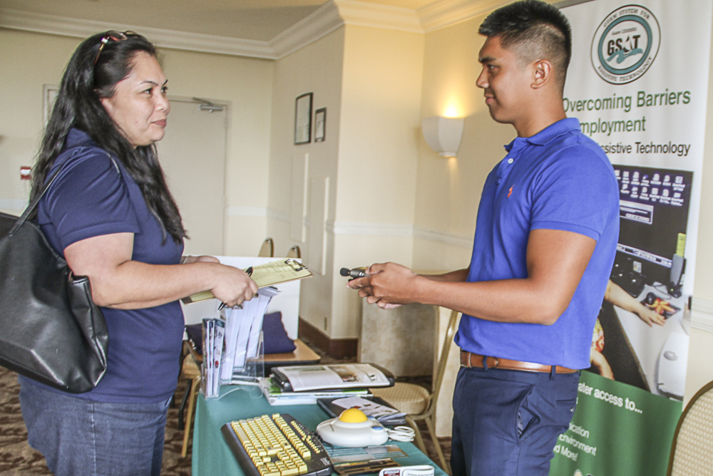 John Guiao, GSAT Support Assistant, explains the use of assistive technology device to Vanessa Paulino, Ambyth Shipping HR Assistant.