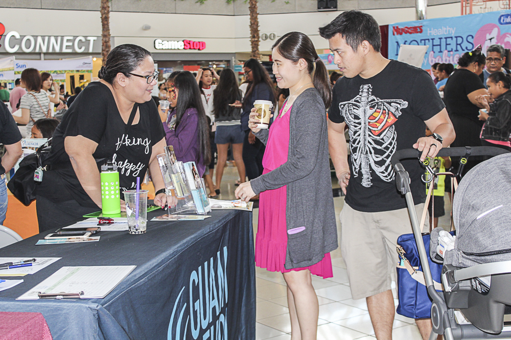 Vera Blaz, CEDDERS Training Associate (left) shares information on the Ages and Stages Questionnaires (ASQ) with parents of young children to determine the developmental status of their child across five developmental areas: communication, gross motor, problem solving, fine motor, and personal-social during the Healthy Mothers, Healthy Babies Fair at the Micronesia Mall on October 29. 